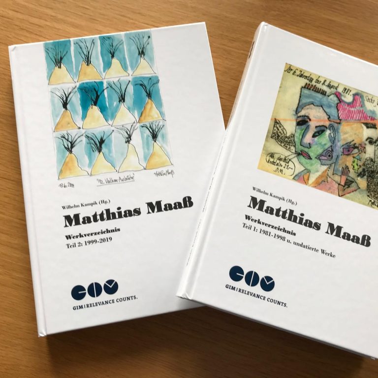 Zwei Exemplare des Werkeverzeichnisses in gedruckter Form, auf einem Holztisch