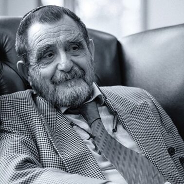 Porträt von Rainer René Mueller in einem Ledersessel.