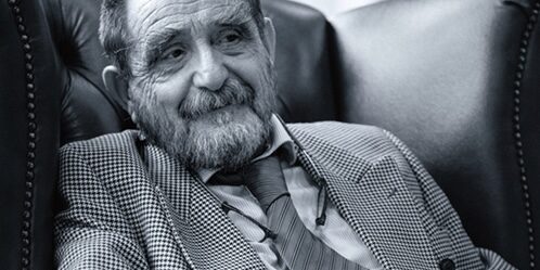 Porträt von Rainer René Mueller in einem Ledersessel.